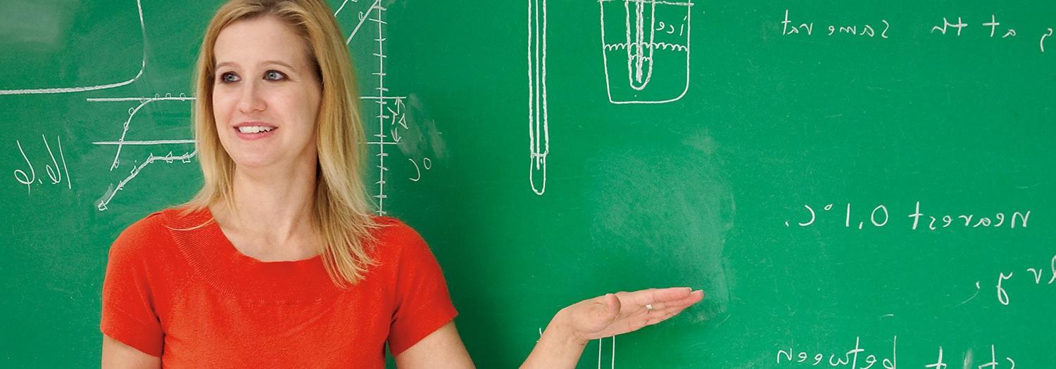 Mathematics professor explaining work shown on a chalkboard