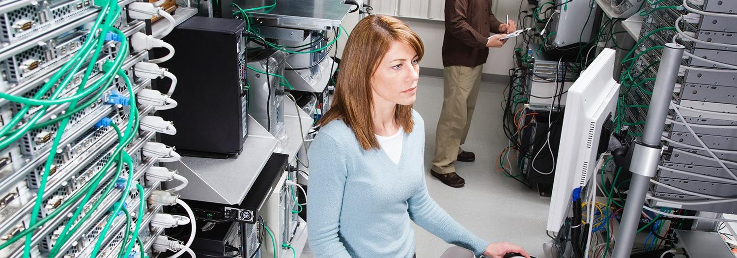 Young lady surrounded by network servers in racks