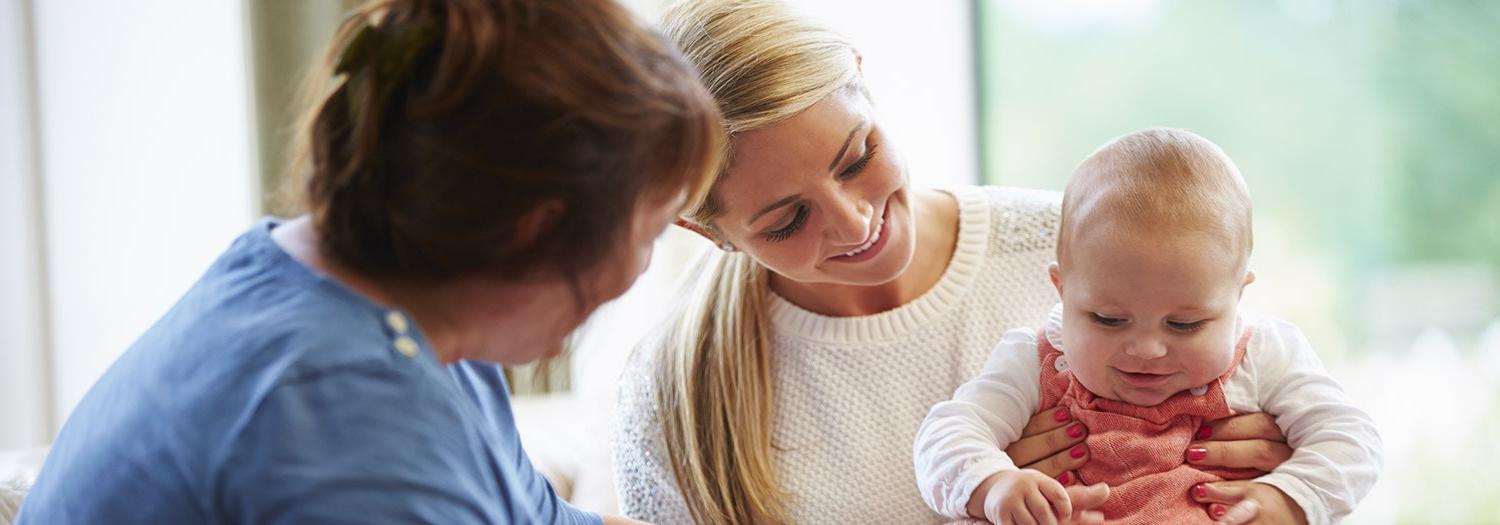 Two women holding a baby