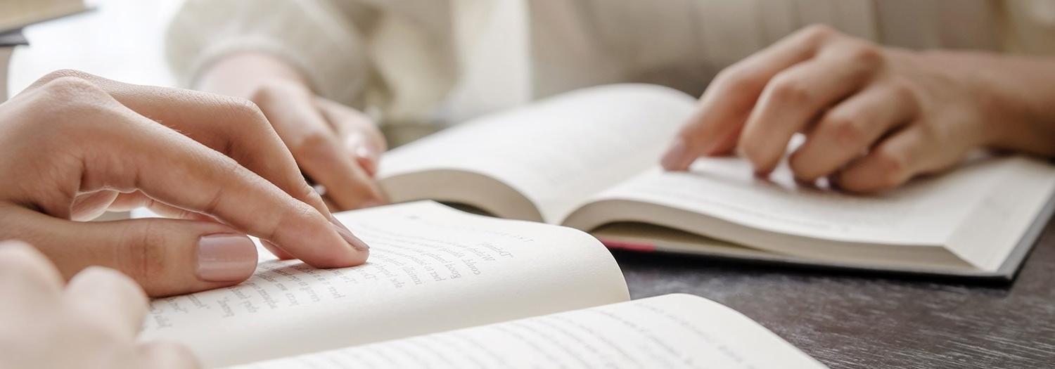 close up of two people reading books